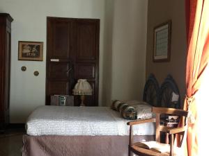 um quarto com uma cama, uma cadeira e uma porta em Casa Brigida em Gênova