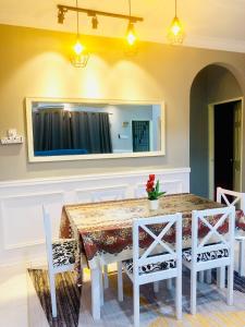 a dining room table with white chairs and a mirror at Homestay Cahaya 2 Seri Iskandar in Seri Iskandar +33 photos