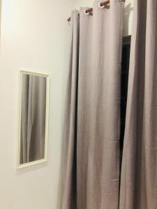 a curtain next to a mirror and a window at Homestay Cahaya 2 Seri Iskandar in Seri Iskandar