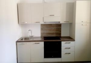 a kitchen with white cabinets and a sink at Soca treasure with free parking in Bovec