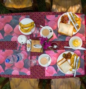 a table with breakfast food and drinks on it at Bandipur Eco Hotel in Bandīpur