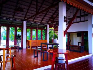 um pátio com mesas e bancos numa casa em Khum Nakhon Hotel em Nakhon Si Thammarat