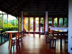 a room with tables and benches in a building at Khum Nakhon Hotel in Nakhon Si Thammarat