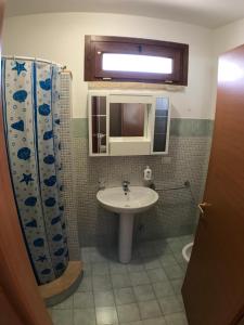 a bathroom with a sink and a shower curtain at WHITE POOL Matino - Gallipoli - 7pl in Matino