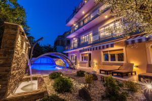 a building with a swimming pool at night at Anikol Apartments in Selce