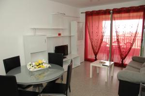 uma sala de estar com uma mesa e um sofá em Accommodation Beach Apartments em Valência
