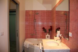 een badkamer met een bad, een wastafel en een spiegel bij NEW Bcomfort in Cagliari