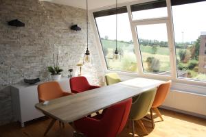 een eetkamer met een tafel, stoelen en ramen bij Ferienwohnung Müller in Göttingen