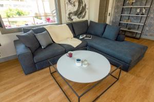 uma sala de estar com um sofá azul e uma mesa branca em Heraklion chic and minimalistic apartment with sea view em Heraclião