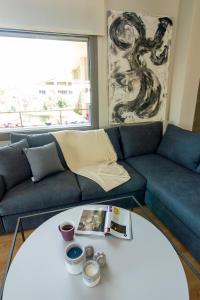 a living room with a couch and a table at Heraklion chic and minimalistic apartment with sea view in Heraklio Town