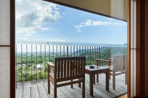 a balcony with a table and chairs and a view of the ocean at Hotel Royal Chiao Hsi in Jiaoxi
