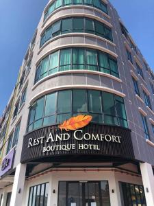 a tall building with a sign on the front of it at Rest And Comfort Boutique Hotel in Kuala Terengganu