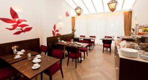 a restaurant with wooden tables and red chairs at Hotel Van Walsum in Rotterdam
