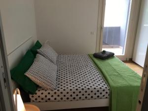 a bed with a green blanket and pillows on it at H1 bzerohome in Elmas