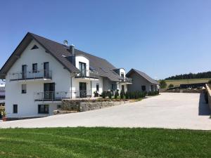 a large white house with a driveway at Landhaus Ferienwohnungen mit Pool und Wellness in Neukirchen-Balbini