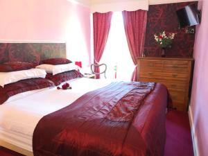 um quarto com uma cama grande e uma cómoda em Arches B&B em St Austell