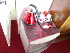 uma mesa com um candeeiro vermelho em cima de uma cama em Arches B&B em St Austell