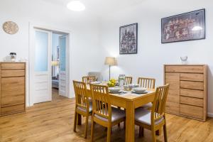 a dining room with a wooden table and chairs at Apartament Na Groblach in Krakow