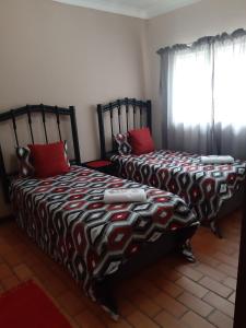 two beds sitting next to each other in a bedroom at Roos Getaway Apartments #8 in Bela-Bela