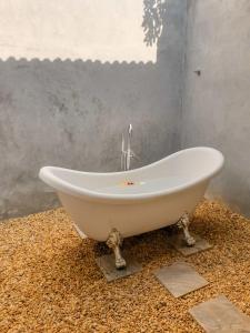 a white bath tub sitting on a floor in a bathroom at Handun Villas in Talalla South