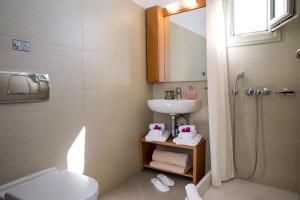 a bathroom with a sink and a toilet and a shower at Irida - Santorini in Imerovigli