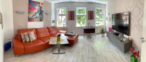 a living room with an orange couch and a table at Ferienhaus Pilse 3 in Erfurt