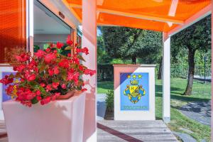 a display of red flowers and a sign under an orange canopy at Hotel Hermitage in Marina di Massa