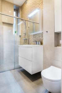 a bathroom with a toilet and a sink and a shower at Apartament Na Groblach in Kraków