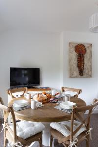 a dining room table with chairs and a tv at First floor flat with parking in Wheatley