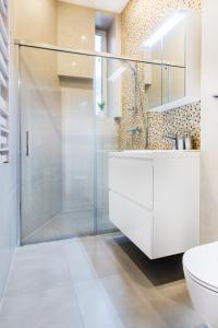 a bathroom with a shower and a toilet and a sink at Apartament Na Groblach in Kraków