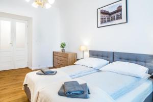 a bedroom with two beds with towels on them at Apartament Na Groblach in Kraków +4 photos