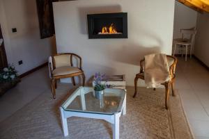 sala de estar con 2 sillas y chimenea en Villa le Rondini, en Castronno