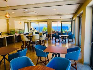 a restaurant with tables and chairs and a view of the ocean at Alexandrina in Mola Kalyva
