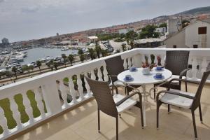 a balcony with a table and chairs and a view of a harbor at Apartment and Rooms Villa Kolonada in Vodice