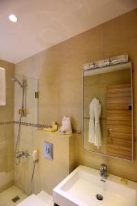 a bathroom with a sink and a shower and a mirror at Mist Hotel & Spa in Ehden