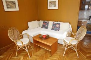 a living room with a white couch and chairs at Apartment and Rooms Villa Kolonada in Vodice