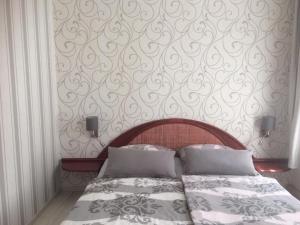 ein Schlafzimmer mit einem Bett und einer Wand mit einem Muster in der Unterkunft Pension Gerber in Erfurt