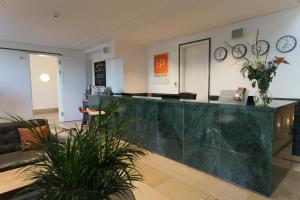 a lobby with a reception desk and clocks on the wall at HighPark Berlin am Potsdamer Platz in Berlin