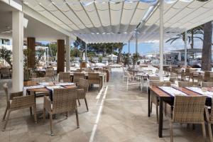 a restaurant with tables and chairs and a view of the ocean at Meliá South Beach in Magaluf