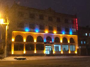 un edificio con luces azules y amarillas. en Midyat GAP Hotel, en Midyat