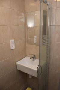 W łazience znajduje się umywalka i przeszklony prysznic. w obiekcie Pod Jabłonią w mieście Szczawnica