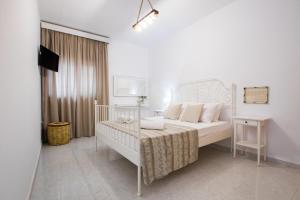 Habitación blanca con cama y cuna en AMALTHIA VILLA, en Karpathos