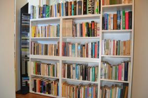 a book shelf filled with lots of books at Joie de Vivre in Calice Ligure