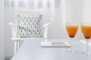 a white chair with a pillow and a glass of orange juice at Antoperla Luxury Hotel & Spa in Perissa