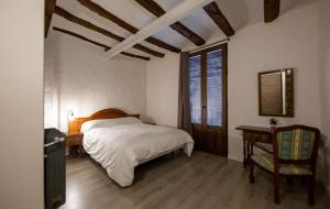 1 dormitorio con 1 cama, 1 mesa y 1 silla en Casa Rural Pradas en Montanejos