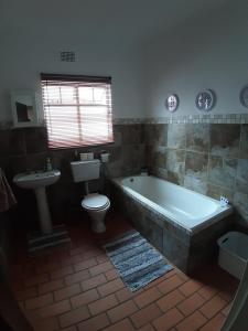 a bathroom with a tub and a toilet and a sink at Roos Getaway Apartments #8 in Bela-Bela