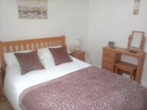 a bedroom with a large bed and a dresser at Sea Dragon in Rye