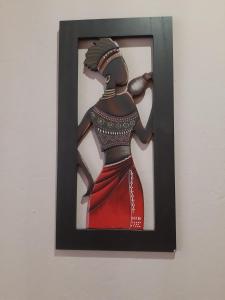 a painting of a woman in a red dress on a wall at Roos Getaway Apartments #8 in Bela-Bela