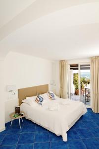 a bedroom with a large bed and a blue floor at Giardino Eden in Ischia