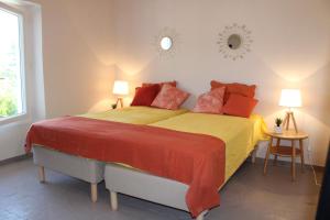 sypialnia z dużym łóżkiem z czerwoną i żółtą pościelą w obiekcie la verdale w mieście Séguret